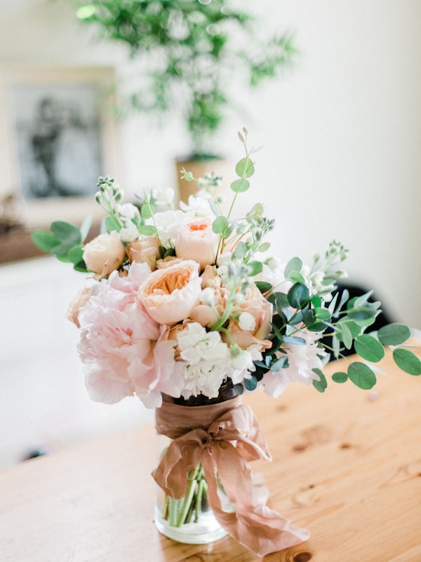 Professional florist arranging beautiful pink roses in a modern flower shop